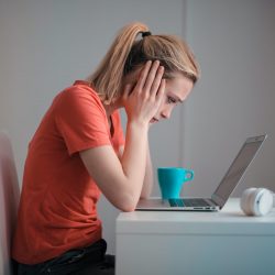 Woman sitting at a desk not sure which Adrenal Fatigue diagnostic test she should take